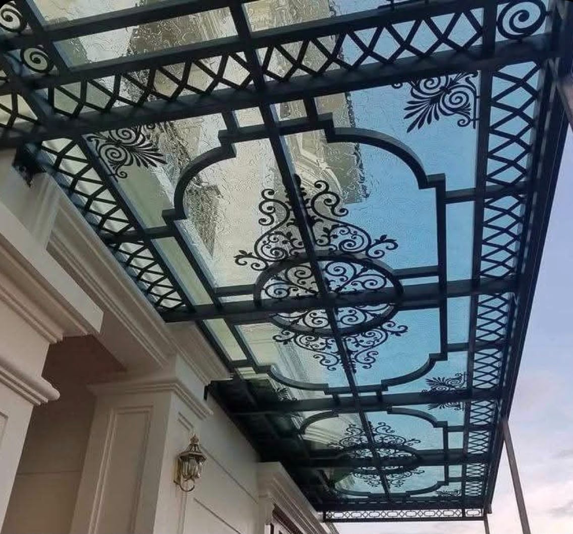 Wrought iron glass canopy with scroll pattern